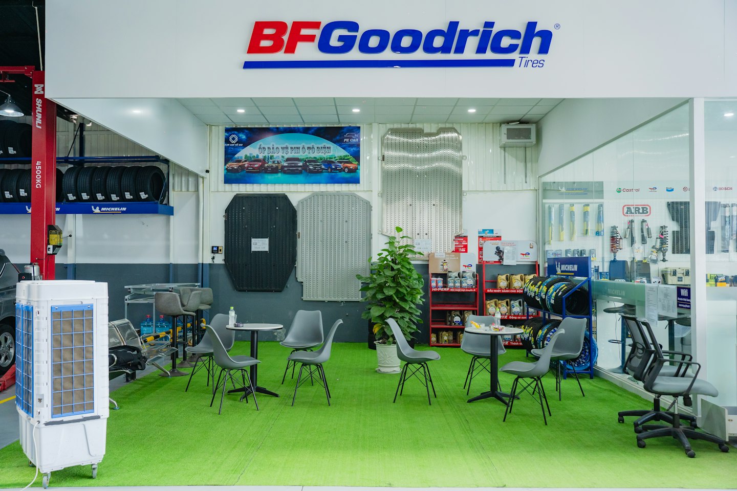 Modern automotive service center waiting area with professional service bays behind.